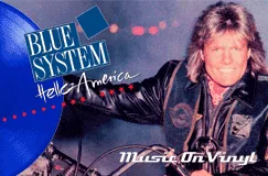 Text: "BLUE SYSTEM, Hello America". Ein Mann mit langen Haaren auf einem Motorrad, freundlich lächelnd. Logo "Music On Vinyl".
