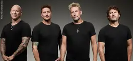 Vier Männer in schwarzen T-Shirts, frontal, neutraler Hintergrund.