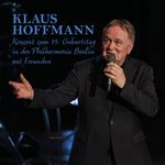 Text: "Klaus Hoffmann. Konzert zum 75. Geburtstag in der Philharmonie Berlin mit Freunden." Mann in dunkelblauem Anzug mit Mikrofon.