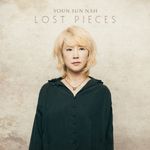 Text: "Youn Sun Nah, Lost Pieces." Eine Frau mit blondem Haar in dunkler Bluse vor einer neutralen Wand.