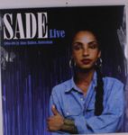 "SADE Live 1984-09-21 Ahoy Hallen, Rotterdam." Frau mit Zopf, blauer Bluse, vor lila Hintergrund.