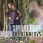 Text: SMOKETREE THE KENNEDYS. Zwei Personen vor einem großen Baum mit verschlungenen Wurzeln, lächeln in die Kamera., CD