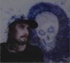 Keine Texte zu sehen. Ein Mann mit langem Haar und Baseballkappe vor einer blauen Totenkopf-Illustration., CD