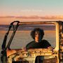 Text „mobil home“. Ein Mann steht am Strand hinter einer rostigen Autotür im sandfarbenen Sonnenuntergang., CD