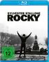 "Sylvester Stallone Rocky" in großen Buchstaben. Darunter eine Figur mit erhobenen Armen auf Treppen; FSK 12 Logo.