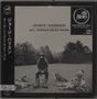 Text: George Harrison, All Things Must Pass, Dark Horse Records. Schwarz-weißes Bild: Person im Gras mit Hüten, Bäume im Hintergrund.