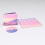 CD und Hülle mit pastellfarbenem Landschaftsmotiv; beigelegtes Blatt zeigt Songtexte in weiß auf rosa Hintergrund., CD