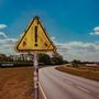 "James Marriott", "Warning Signs". Ein altes, dreckiges gelbes Warnschild vor einer Landstraße und blauem Himmel., CD