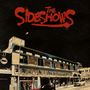 "The Sideshows" in roter Schrift, dekorativ mit alten Gebäuden, Plakaten und Straßenlaterne im Hintergrund., CD