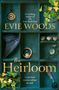 Ein Regal mit einer alten Uhr, Muscheln, einem Federkiel, Efeu und einem Flügel. "Evie Woods - The Heirloom" steht groß geschrieben., Buch