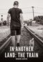 „IN ANOTHER LAND: THE TRAIN, MANUEL GARCÍA“. Ein Mann und ein kleiner Hund gehen eine Bahnschiene entlang., Buch