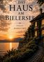 "Das Haus am Bielersee. Roman Markus Red." Sonnenuntergang über einem See, neben einem malerischen Steinhaus mit Garten., Buch