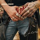 "Tokyo Hotel", "Encore". Tätowierte Hände mit Ringen halten einen Gürtel. Jeans und Lederjacke mit Nieten.