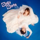 Text: "GiGi Girls". Zwei Frauen in weißen Kleidern, auf blauem Hintergrund liegend, eine schaut nach oben, die andere zur Seite.