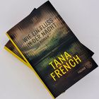 Zwei Bücher mit dem Titel "Wie ein Fluss in der Nacht" von Tana French. Cover mit einem dunklen, abstrakten Hintergrund.