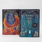 Zwei Bücher: "TALE OF SUN AND NIGHT" mit einem Phönix, "MEMORIES OF STARS AND DUST" mit einem Hirsch und Blättern.