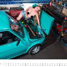 Text: "OKTOBER". Eine Frau in Jeansshorts posiert auf einem offenen türkisfarbenen Auto in einer Werkstatt.