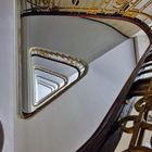 Spiral-Treppenhaus mit kunstvollen, goldenen Geländern und Blick nach oben in die Spitze des Treppenturms.