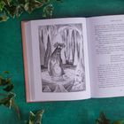 Text: "The Hobbit". Eine Illustration zeigt eine Brücke mit Figuren darauf, darunter fließt ein Fluss mit Booten.