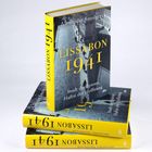 „LISSABON 1941“ steht in Gelb auf einem Buchcover, das auf gestapelten Büchern liegt.
