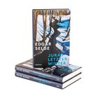 "Edgar Selge - Juras letzter Winter. Roman." Ein Buchstapel mit Cover zeigt eine winterliche Waldszene in Blautönen.
