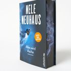 "Nele Neuhaus", "Alles wird Asche", "Limitierte Sonderausstattung", "ullstein". Ein Buchcover mit Rauch und einem Vogel.