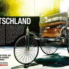 „Deutschland“ steht groß im Bild. Ein altes Automobil, ähnlich einer Kutsche, ist rechts daneben abgebildet.