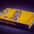 Text auf gelbem Buchdeckel: "Lakers: An Official History of the Purple & Gold". Design erinnert an ein Sporttrikot.