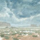 Illustration einer Wüstenlandschaft mit Felsen und niedrigen Hütten, bei starkem Regen und bewölktem Himmel.