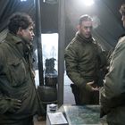 Kein Text erkennbar. Drei Männer in Militäruniformen besprechen sich in einem Zelt über einer Karte auf einem Tisch.