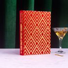 „Murder at the Grand Alpine Hotel“ steht auf dem rot-goldenen Buchrücken. Ein Martini-Glas daneben.