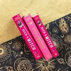 Buchrücken von "Such a Witch" von Sarah Henning; pink mit kleinen Illustrationen von Figuren und Symbolen. Darunter ist ein Muster mit Sternen.