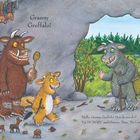Text: "Granny Gruffalo!"; "Hello, Granny Gruffalo! How do you do?" "I'm HUNGRY," said Granny. Then, "Do I smell stew?"

Illustration einer Höhle mit drei Gruffalos. Einer hält einen Löffel.