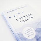 „ÜBER DIE TRAUER: Geschichten von Abschied, Trost und Hoffnung.” Cover mit fliegenden Vögeln und blauer Landschaft.