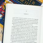 Ein aufgeschlagenes Buch zeigt das Kapitel 4 mit dem Titel "VIOLET". Darunter beginnt der Text: "ALLE TAGE: GLEICH, GLEICH, GLEICH."