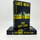 Text: "Lars Menz: Der gute Sohn, Kriminalroman." Cover: Dunkle Szene mit beleuchtetem Turm.
