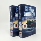 Die Buchcover zeigen "Stefan Ahnhem" und "Haustausch", mit Netflix-Logo und einem Strudel im Wasser nahe einem Haus.