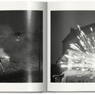 "TATI SHOOTS" oben links, "MONSIEUR HULOT'S HOLIDAY" oben rechts. Links: Eine Person mit Hut bei Nacht. Rechts: Feuerwerk.