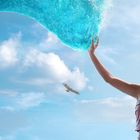 Ich kann keine Texte erkennen. Eine Frau berührt eine große Wasserwelle im Himmel, und ein Vogel fliegt im Hintergrund.