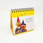Kalender mit gelbem Umschlag, Ernie und Bert in Partyhüten. Text: "Das größte Geschenk ist nicht unter dem Baum, sondern die...".