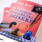 "Rita Falk. FLEISCH-PFLANZERL-MISERE. Ein Provinzkrimi. SPIEGEL Bestseller-Autorin." Cover mit Ente, Essen und Gewehr.