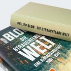 Zwei Bücher von Philipp Blom: "Die Strauchelnde Welt". Eines hat einen grünen Einband, das andere ein farbiges Cover.