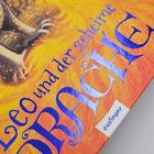 Text: „Leo und der geheime DRACHE“, "esslinger". Illustration eines Drachen auf orange-gelbem Hintergrund.
