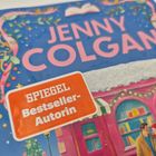 Der Text "SPIEGEL Bestseller-Autorin" ist auf einem orangefarbenen Sticker. Dekorative Elemente und ein Paar vor einem Buchladen.