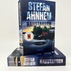 „STEFAN AHNHEM HAUSTAUSCH“, Thriller. Netflix-Logo. Zwei Buchrücken mit dunkler, düsterer Landschaft.