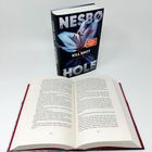 Oben: "NESBØ KILL SHOT HOLE". Bild zeigt ein florales Cover mit einem Buch darunter aufgeschlagen, Seiten 256-257.