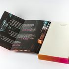 „GILLY MACMILLAN, Die Bibliothek“, gefolgt von lebhaften Lobzitaten. Aufgeschlagenes Buch mit buntem Buchschnitt.