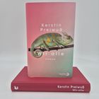 Buchcover-Text: Kerstin Preiwuß, wir alle, Roman, berlin Verlag. Ein Chamäleon auf einem Ast auf rosa-grünem Hintergrund.