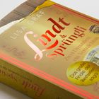 Buchcover mit dem Titel: "Lindt & Sprüngli: Zwei Dynastien, ein Vermächtnis". Goldene Schokoladenverpackung oben.