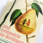 „Und mittendrin der Birnbaum“ steht auf einem Buchcover mit einer großen Birne und zwei Personen.